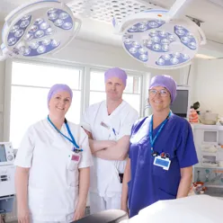 Tre sykepleiere inne på en operasjonsstue