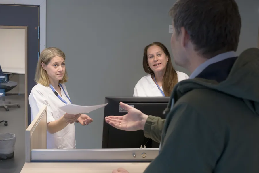 To merkantile snakker med en pasient i en resepsjon