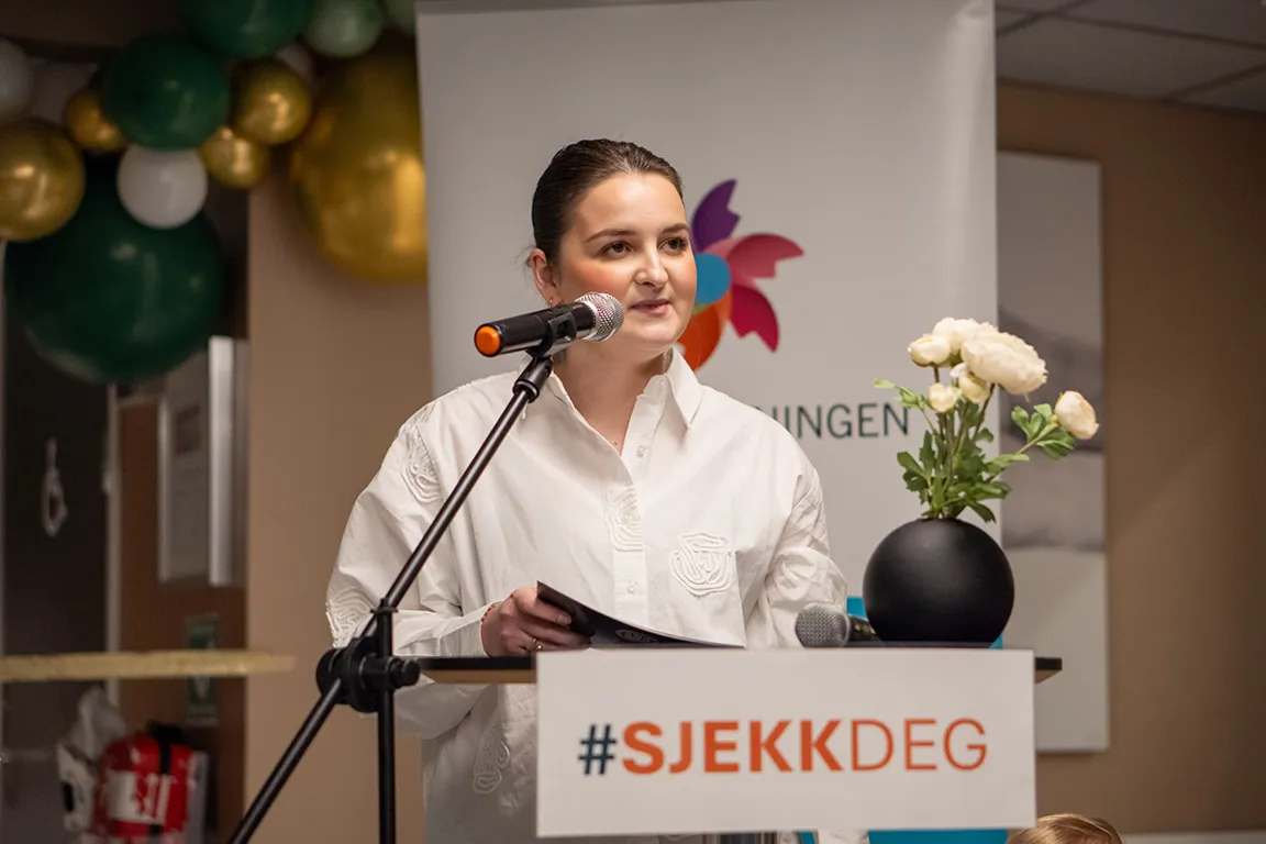 En person som snakker inn i en mikrofon