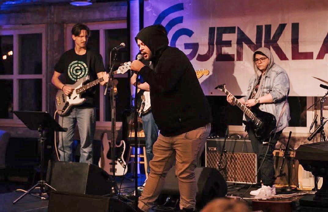 En gruppe menn som spiller instrumenter på en scene