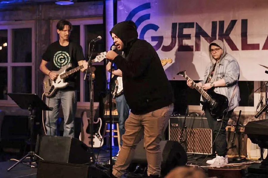 En gruppe menn som spiller instrumenter på en scene