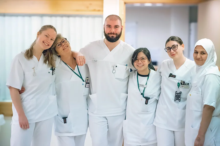 En gruppe ansatte ved Betanien iført hvite laboratoriefrakker og poserer for et bilde