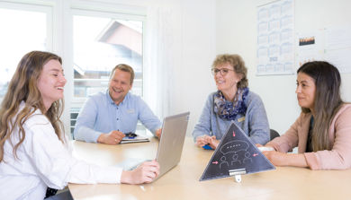 En gruppe mennesker som sitter rundt et bord