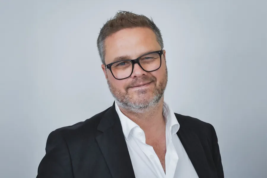 Portrett av Lars-Petter, iført briller, dressjakke og hvit skjorte.