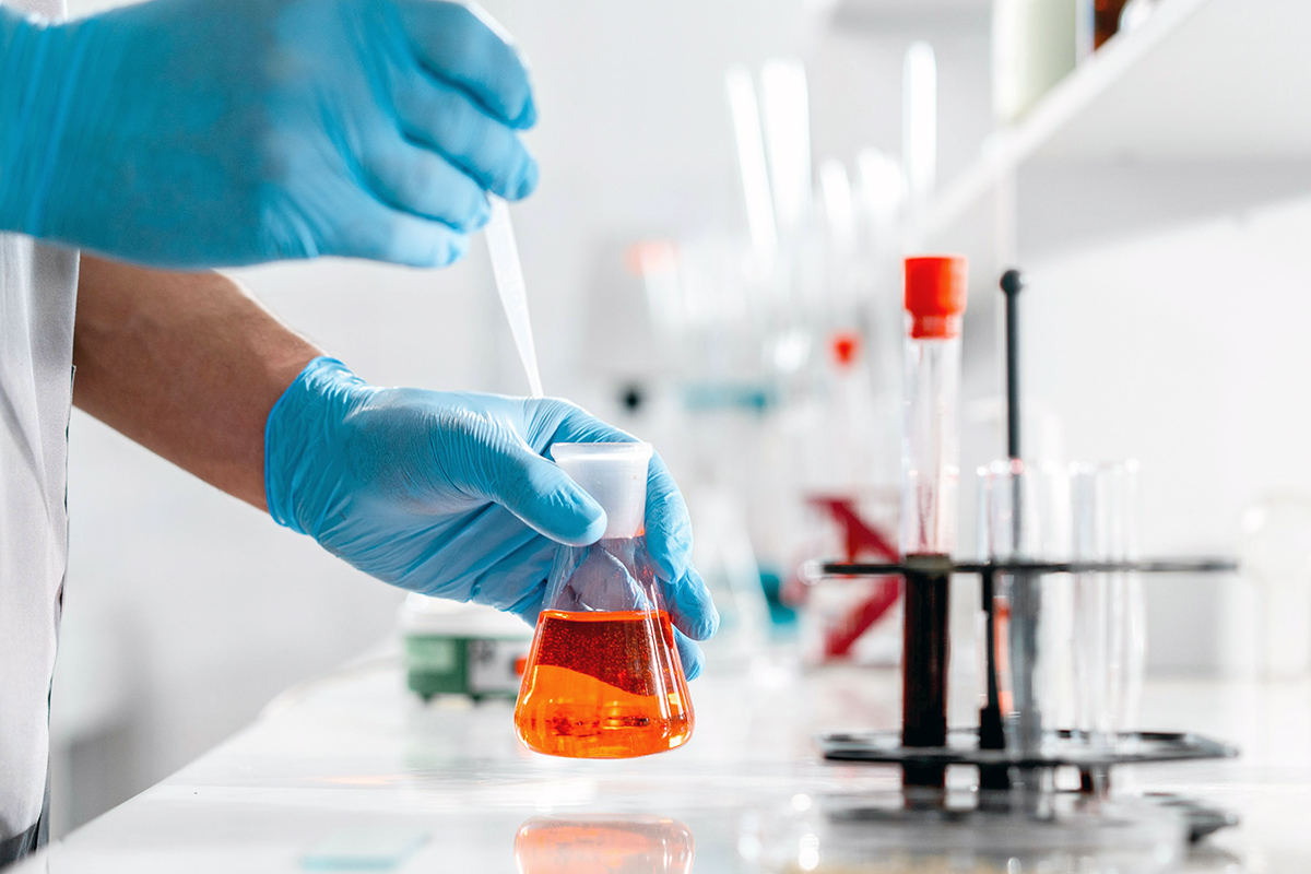 En person som bruker en kolbe på et laboratorium